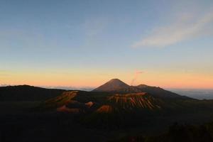 View of Mount Bromo in the morning with the peaks of Mount Semeru in the background photo