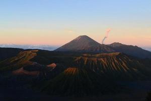 View of Mount Bromo in the morning with the peaks of Mount Semeru in the background photo