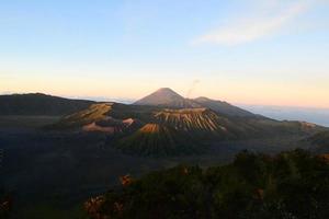 View of Mount Bromo in the morning with the peaks of Mount Semeru in the background photo