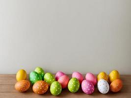 A row of colorful easter eggs with polka dots on a wooden table photo