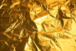 Design space gold crumpled foil paper textured background. photo