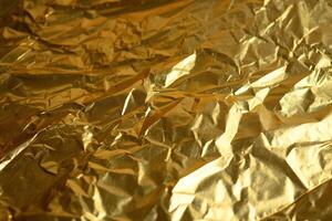 Design space gold crumpled foil paper textured background. photo