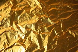 Design space gold crumpled foil paper textured background. photo