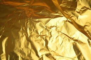 Design space gold crumpled foil paper textured background. photo