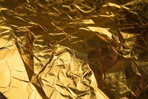 Design space gold crumpled foil paper textured background. photo