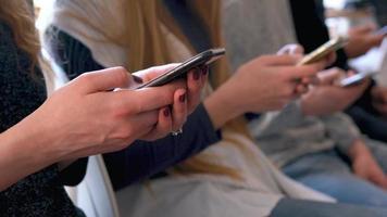 Gruppe von Menschen verwenden Handy, Mobiltelefon Telefone im ein Cafe stattdessen von kommunizieren mit jeder andere video