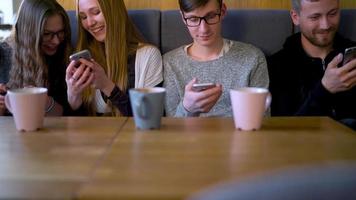 groupe de gens utilisation mobile Téléphone (s dans une café au lieu de communicant avec chaque autre video