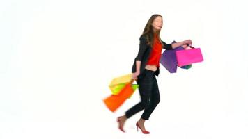 weiblich Käufer halten mehrfarbig Einkaufen Taschen auf Weiß Hintergrund im Studio. Lasst uns gehen Einkaufen Konzept video