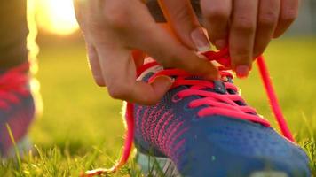 Running shoes - woman tying shoe laces. Slow motion video