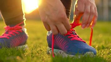 Running shoes - woman tying shoe laces. Slow motion video