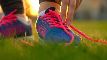 Running shoes - woman tying shoe laces. Slow motion video