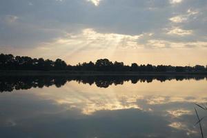 Landscape of lake in the forest. Trees reflection in the water. Summer holidays landscape. photo