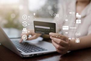 Woman holding credit card for makes a purchase on the Internet on the laptop computer with credit card, online payment, shopping online, e-commerce, internet banking, spending money concept. photo