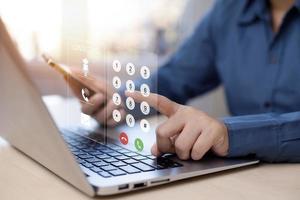 Communication and Contact us or Customer support hotline people connect. Hand using a laptop and touching on virtual screen contact icons, email and address, Chat bot, and live chat with internet wifi photo
