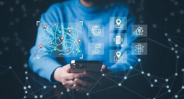 Man using Smartphone with virtual world and model map with location point, GPS app, icon Travel maps and find places in the online system, all screen graphics are generated, Searching for travel. photo