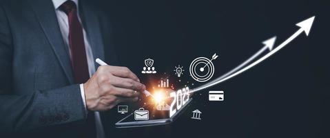 2023 and Startup concept with icon business and network connection on modern virtual interface from digital tablet.Businessman Touching tablet and graph Screen Icon of media screen, Technology Process photo