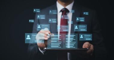 Businessman hand touch Online documentation database, complete the online survey form, answer the test questions. Marked checklist on a clipboard. Human resources and management concept. photo
