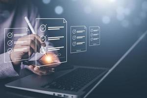 Signing electronic documents on digital documents Online and checklist and clipboard task documentation management,  working laptop checklist questionnaire assessment form, online survey online exam. photo