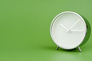 alarm clock on green background time concept working with time precious time photo