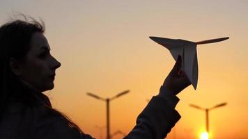 mulher lançamentos papel avião contra pôr do sol fundo. conceito do querendo para ir em período de férias ou viagem video