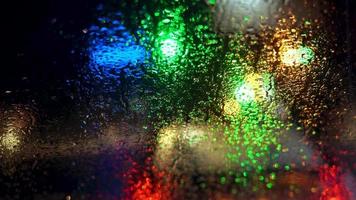 fechar acima chuva gotas em carro janela vidro com borrado noite cidade carro luzes bokeh Como fundo video