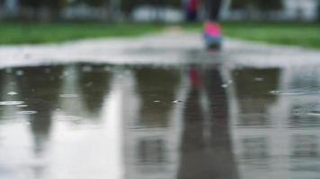 stänga upp skott av ben av en löpare i sneakers. kvinna sporter man joggning utomhus i en parkera, stepping in i grumlig pöl video