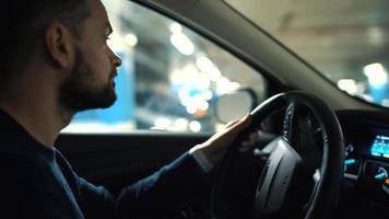 Man driving car through a parking lot and is looking for a place to park or driving away video