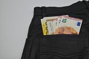 euro cuentas en el espalda bolsillo de un mujer cuero pantalones foto