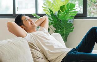 retrato de asiático hombre sentado en sofá a hogar foto