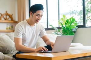 portrait of asian man sitting on sofa at home photo