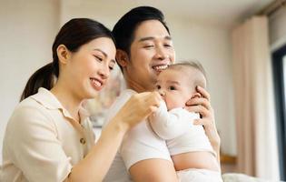 Smiling mother and father holding newborn son at home photo