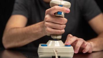 Young man using old fashioned joy stick playing on video game