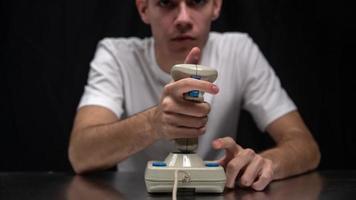 Young man using old fashioned joy stick playing on video game