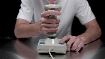 Young man using old fashioned joy stick playing on video game