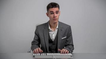 Young businessman in suit using computer keyboard at work video