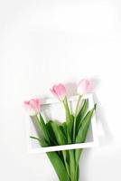 Flowers pink tulips in photo frame on white background. Wedding. Birthday. Happy woman's day. Mothers Day. Valentine's Day. Flowers composition romantic. Flat lay, top view, copy space