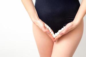 Woman holding sugar cubes on bikini zone, the concept of intimate depilation, problems of intimate hygiene. photo