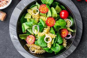 fresh salad pasta, tomato, cucumber, green leaf mix, Fusilli meal food snack on the table copy space food background rustic top view photo