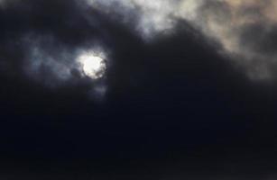 view on sun behind dark clouds photo