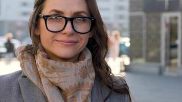 portrait de une femme avec une coiffure et neutre maquillage sur une ville Contexte fermer video