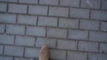 Top view of female legs in boots walking on the sidewalk video