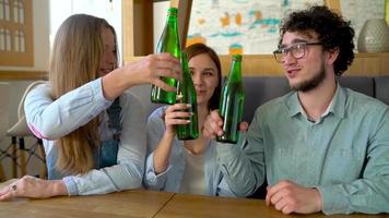 joven amigos sentar en un cafetería, bebida café y tener divertido comunicado. lento movimiento video