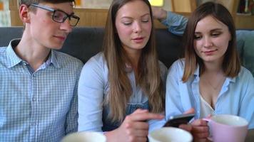 jong vrienden zitten in een cafe, drinken koffie en hebben pret communiceren. langzaam beweging video