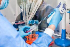 Young scientist working in a safety laminar air flow cabinet at laboratory photo