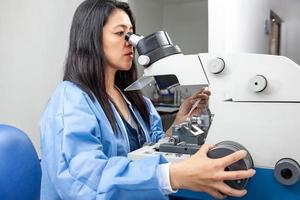 joven hembra científico utilizando un ultramicrótomo a hacer secciones para el electrón microscopio foto
