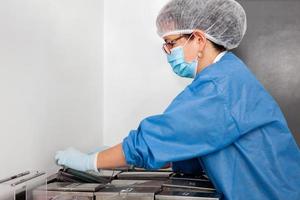Female scientist staining microscope slides for cytology studies in the laboratory. photo
