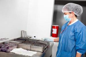 Female scientist staining microscope slides for cytology studies in the laboratory. photo