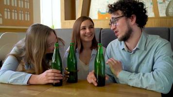 Young friends sit in a cafe, drink coffee and have fun communicating. Slow motion video