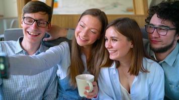 Young friends sit in a cafe, drink coffee and have fun communicating. Slow motion video