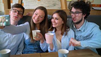 jovem amigos sentar dentro uma cafeteria, beber café e ter Diversão comunicando. lento movimento video